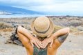 Woman viewed from back enjoy nature and scenic place with coastline and blue sky in background. Travel tourist people admiring