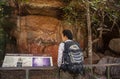 A woman viewing the painting of Creation Ancestor, Namondjok and Namarrgon or the Lighting Man at Nourlangie in Kakadu, Australia