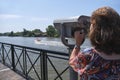 Woman viewing through public binoculars, Lujan river bank, Tigre, Argentina Royalty Free Stock Photo