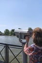 Woman viewing through public binoculars, Lujan river bank, Tigre, Argentina Royalty Free Stock Photo