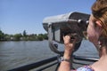 Woman viewing through public binoculars, Lujan river bank, Tigre, Argentina Royalty Free Stock Photo