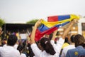 Woman vigorously holding Venezuelan flag at protest