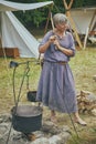 A woman at the Viking festival boils clothes in herbs