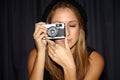 Woman, vintage camera and photographer in dark background, picture and hipster. Serious, youth and hobby with Royalty Free Stock Photo