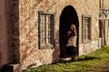 Woman in vintage clothes stands at the arch of a retro house. Architecture of buildings of the European middle ages