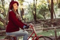 Woman in vintage fashion riding bike on fall day Royalty Free Stock Photo