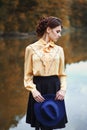 Woman with vintage hat near the river in autumn season Royalty Free Stock Photo