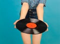 Woman with vinyl record on blue background