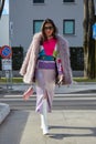 Woman with violet purple fur coat and skirt before Emporio Armani fashion show, Milan Fashion Week street