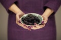 Woman in violett 50`s dress hands holding some blackberries