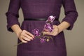 Woman in violett 50`s dress hands holding some orchid flowers Royalty Free Stock Photo