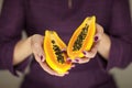 Woman in violett 50`s dress hands holding some papayas
