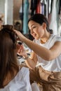 Woman visagist applying makeup cosmetic to female client getting ready. Make up artist working