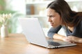Woman with vision problems forcing sight reading on laptop Royalty Free Stock Photo