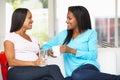 Woman Visiting Pregnant Friend At Home Royalty Free Stock Photo