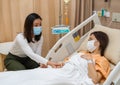 Woman visiting and take care female patient on bed at hospital. people must be wearing medical mask to prevention coronavirus Royalty Free Stock Photo
