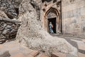 Woman visitor entering at Geghard Monastery in Armenia. It is an important travel and religious pilgrimage point in Kotayk