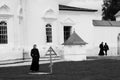 Tobolsk, Russia, 10/05/2016: A woman visits the grave in a monastery. In the background are the priests. Black and white