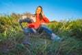 Woman sitting outside on the grass and live streaming with smartphone and gimbal