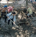 Woman volunteer cleaning dirt with a shovel.