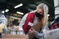 Woman volunteer in community charity donation center, food bank and coronavirus concept. Royalty Free Stock Photo