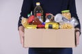 Woman volunteer hands holding food donations box with food grocery products