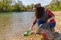 Woman volunteer helps clean the shore of river of garbage. Earth day and environmental improvement concept. Eco