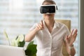 Woman in VR headset touching virtual objects