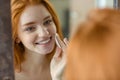 Woman with wadding looking at her reflection in mirror