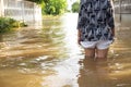 Woman wade flooding in her house. Closeup on her leg. View behin
