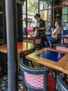 Woman waiter clears Paris cafe table