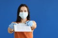 Woman waiter in protective medical mask and gloves giving clipboard with documents and pen for signature closeup