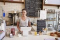 Woman waiting behind the counter at a coffee shop, close up Royalty Free Stock Photo