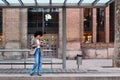 woman waiting at the bus stop checking her phone