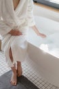 Woman waiting until hot water fill the bathtub