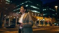 Woman waiting night taxi in downtown. Successful businesswoman hold mobile phone