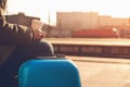 Woman waiting at railway station. Travel by train. Girl drinks coffee and waiting train. Woman with blue luggage suitcase in morni Royalty Free Stock Photo