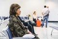 Woman waiting seated on the airport`s departure lounge