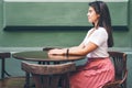 Woman waiting in cafe while sitting on wooden chear