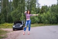 Woman waiting to help and showing thumbs up near her broken car