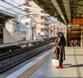 A woman waiting for the train at station in Kyoto, Japan