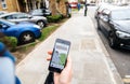 Woman waiting for the uber car on the street holding smartphone Royalty Free Stock Photo