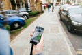 Woman waiting for the uber car on the street holding smartphone Royalty Free Stock Photo