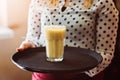 Woman waitress holding fresh delicious pineapple cocktail