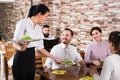 Woman waitress serving meal for cafe guests Royalty Free Stock Photo