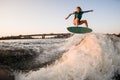 woman wakesurfer skilfully jumping on wakesurf over great splashing river wave Royalty Free Stock Photo