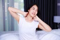 Woman waking up and hand raised on bed in bedroom Royalty Free Stock Photo