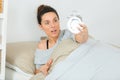 Woman waking up late in morning turning off alarm clock Royalty Free Stock Photo