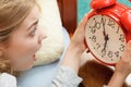 Woman waking up late turning off alarm clock. Royalty Free Stock Photo