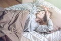 Woman waking up in the morning, lying sleepy in bed